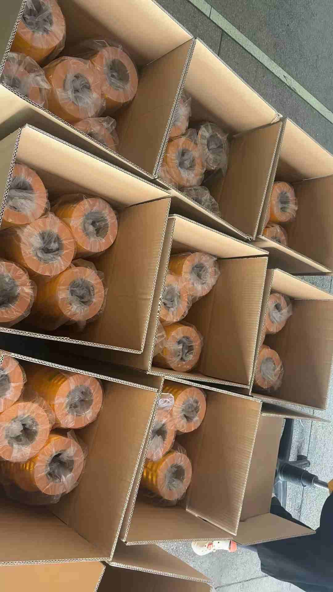 Open cartons filled with finished tape rolls in the packing area